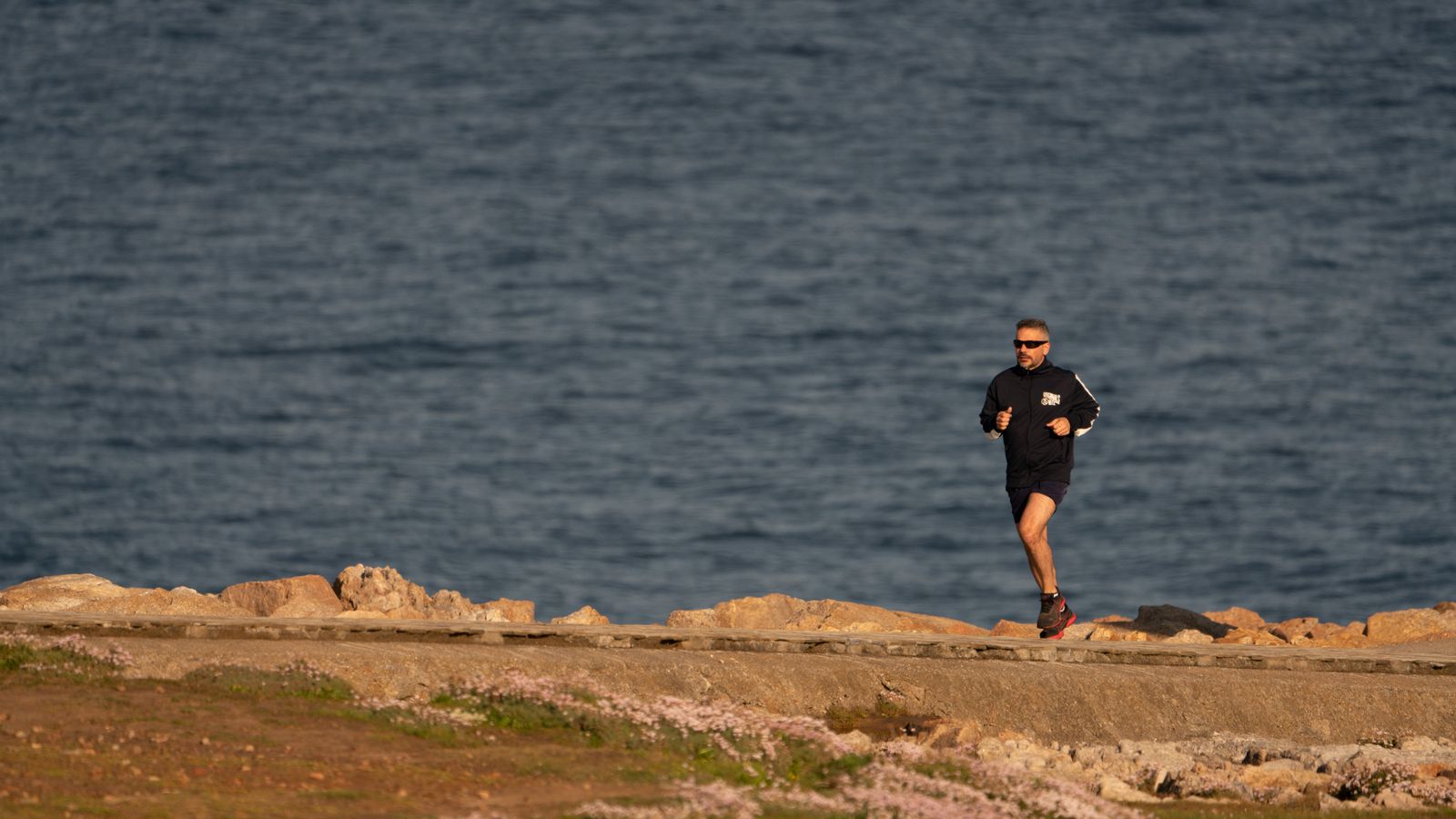 Coureur sur un sentier côtier face à la mer
