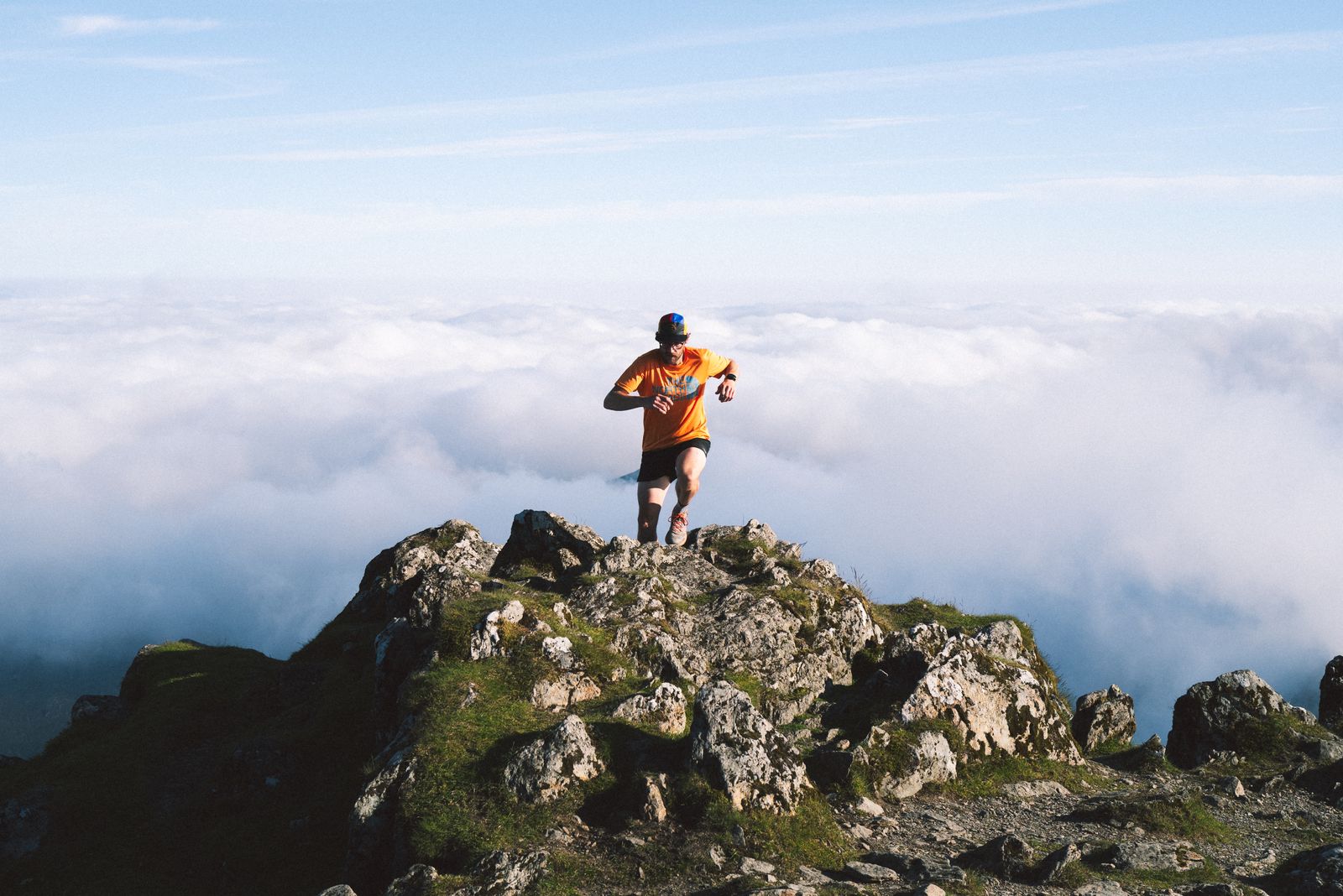 Traileur au sommet d'une montagne au-dessus d'une mer de nuages