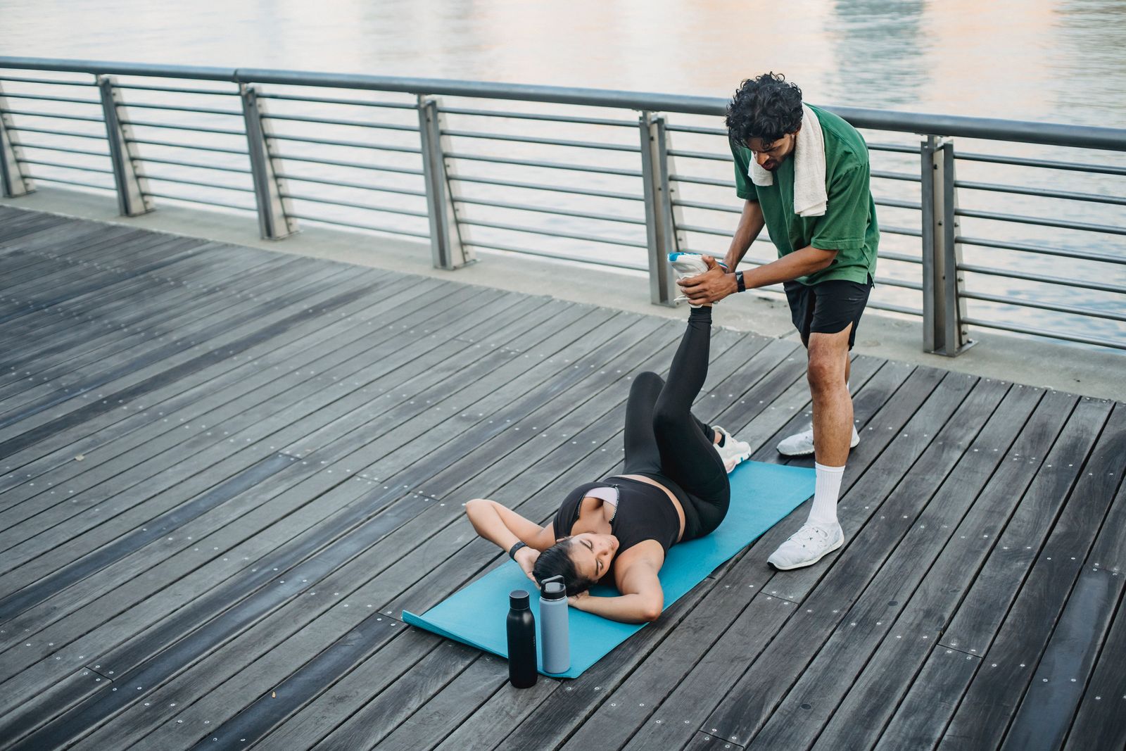 Coach sportif accompagnant une séance de renforcement en extérieur